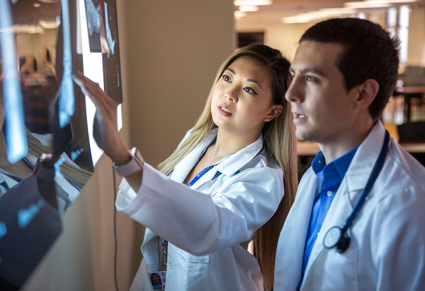 two students using smart board to look at x rays.